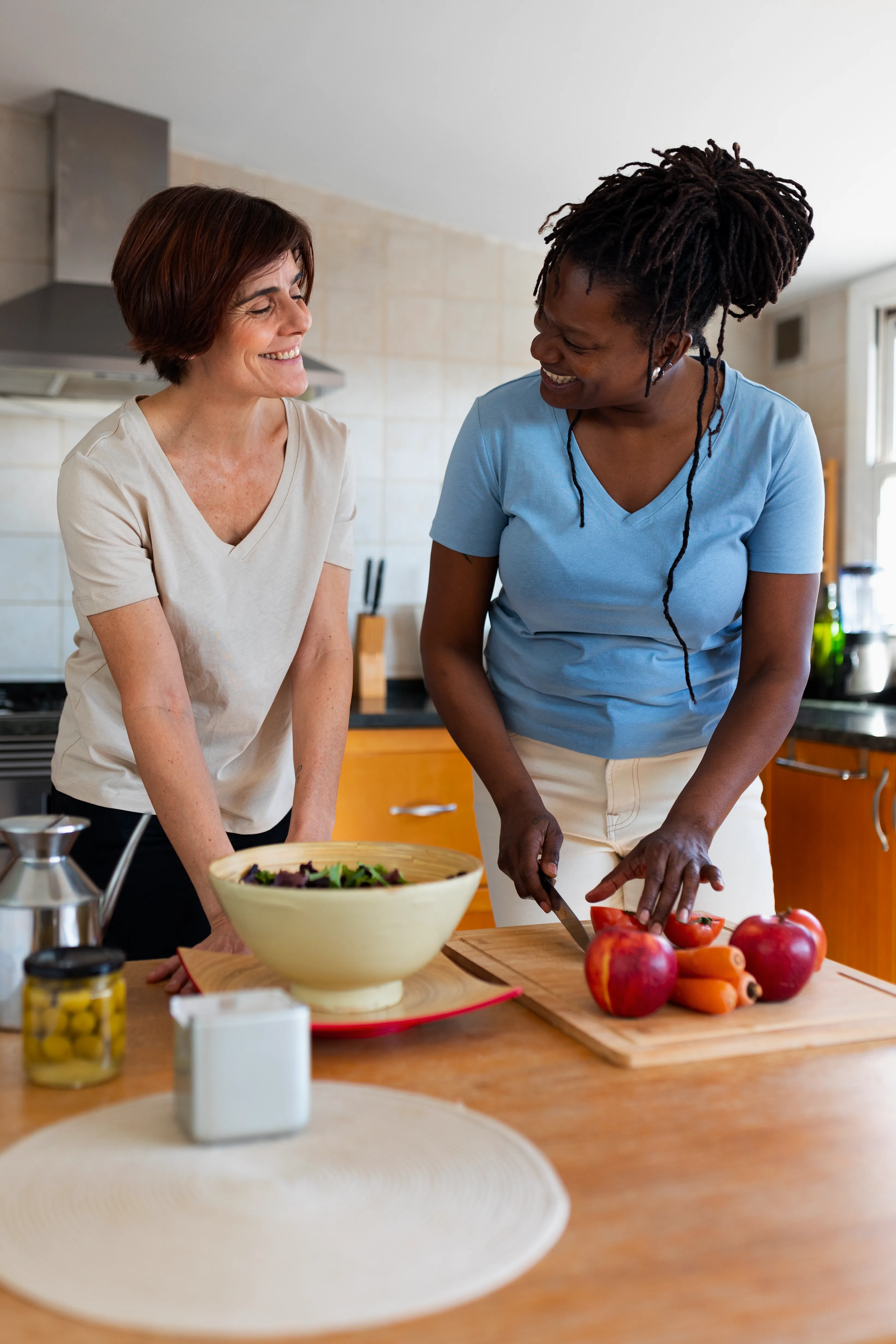 Morning Star caregiver prepares fresh food while sharing a warm smile with a woman in their kitchen.
